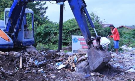 Meratakan tumpukan Sampah di jln. barito